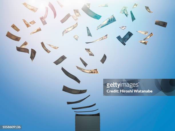 stack of currencies blowing away. ( japanese yen ) - wasting money stock pictures, royalty-free photos & images