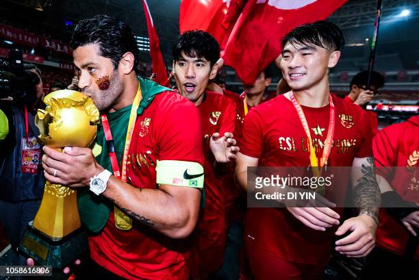 Hulk kisses of Shanghai SIPG kisses the Chinese Super League trophy after winning the Chinese Super League championship against Beijing Renhe during...