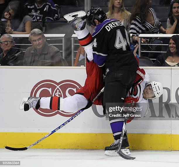 Tuomo Ruutu of the Carolina Hurricanes is checked into the boards by Davis Drewiske of the Los Angeles Kings during the third period at Staples...