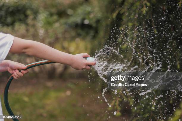 holding water rubber hose tube. watering - spray nozzle stock pictures, royalty-free photos & images