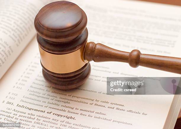 judges gavel on book about copyright infringement  - copyright stock pictures, royalty-free photos & images