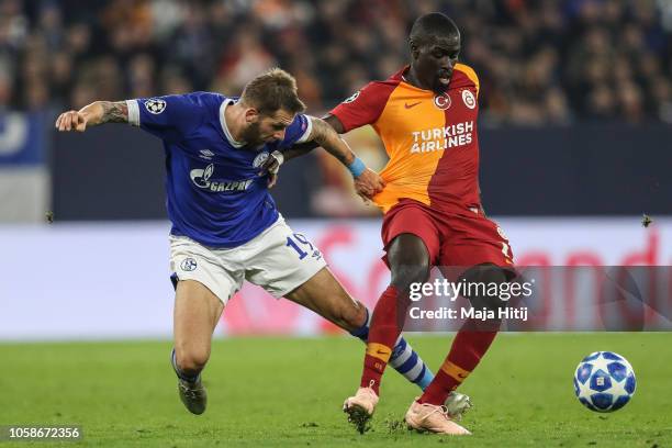 Badou Ndiaye of Galatasaray is challenged by Guido Burgstaller of FC Schalke 04 during the Group D match of the UEFA Champions League between FC...