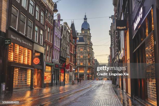 famous leidsestraat street illuminated at dawn, amsterdam, netherlands - shopping street stockfoto's en -beelden