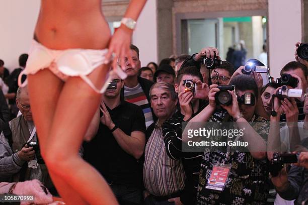 Visitors photograph a stripper performing on the industry professionals' day at the 2010 Venus Erotic Fair at Messe Berlin on October 21, 2010 in...