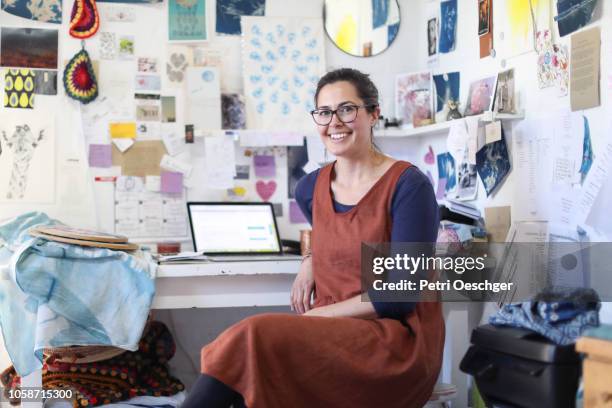 a woman working on her laptop in her home studio. - product design stock-fotos und bilder