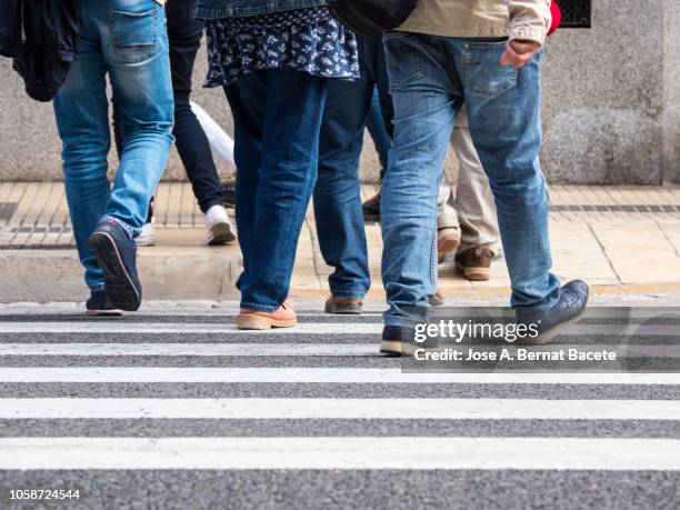 persons crossing crosswalk a street in the city walking in autumn. - walk dont walk signal stock pictures, royalty-free photos & images