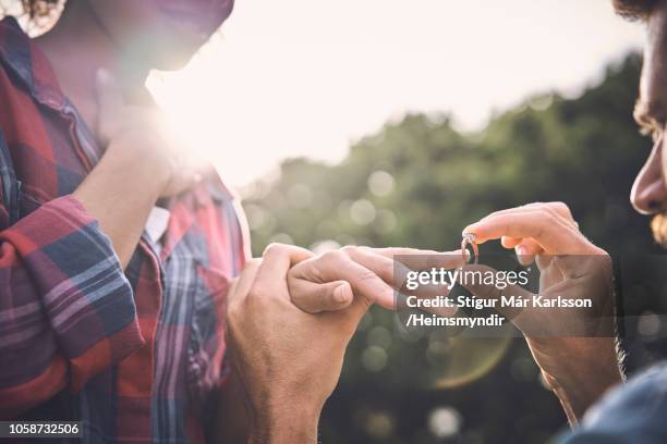 primo primo dell'uomo che mette l'anello sul dito della donna - engagement ring foto e immagini stock