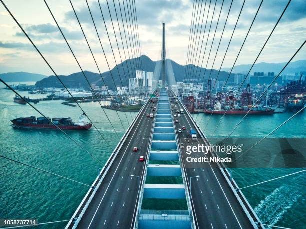 brücke in hongkong und container cargo frachtschiff - china stock-fotos und bilder