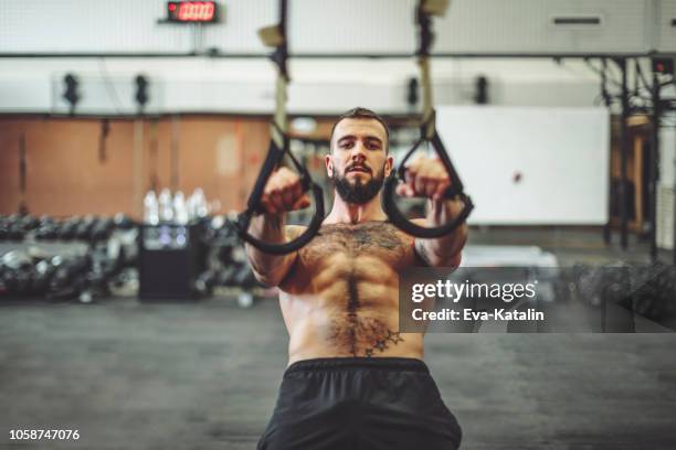 strong man is doing cross training exercise - suspension training stock pictures, royalty-free photos & images