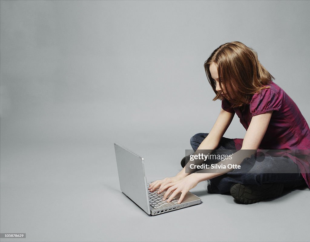 Teenager sitting with her computer