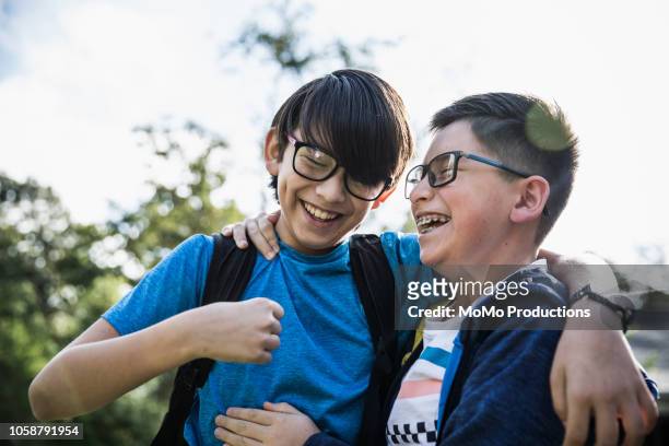 school age brothers laughing outdoors - love connection family stockfoto's en -beelden