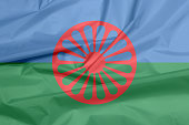 Fabric flag of Romani people. Crease of the Gypsies flag background.