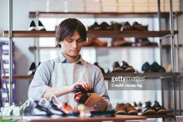若い男の靴を磨き靴磨き - 靴をみがく ストックフォトと画像
