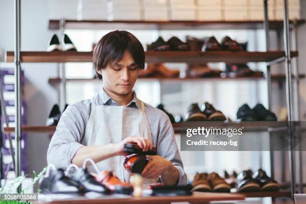 young man shoeshiner polishing shoes - shoeshiner stock pictures, royalty-free photos & images