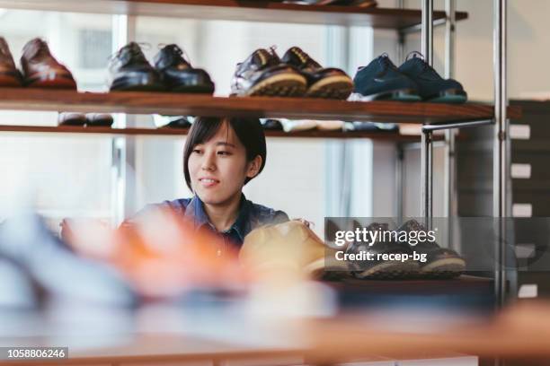 vrouw werken bij schoenenwinkel - schoenenwinkel stockfoto's en -beelden