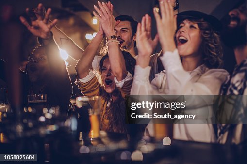Friends in pub watching match Friends in pub watching match