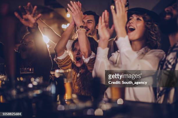 friends in pub watching match - cheering stock pictures, royalty-free photos & images