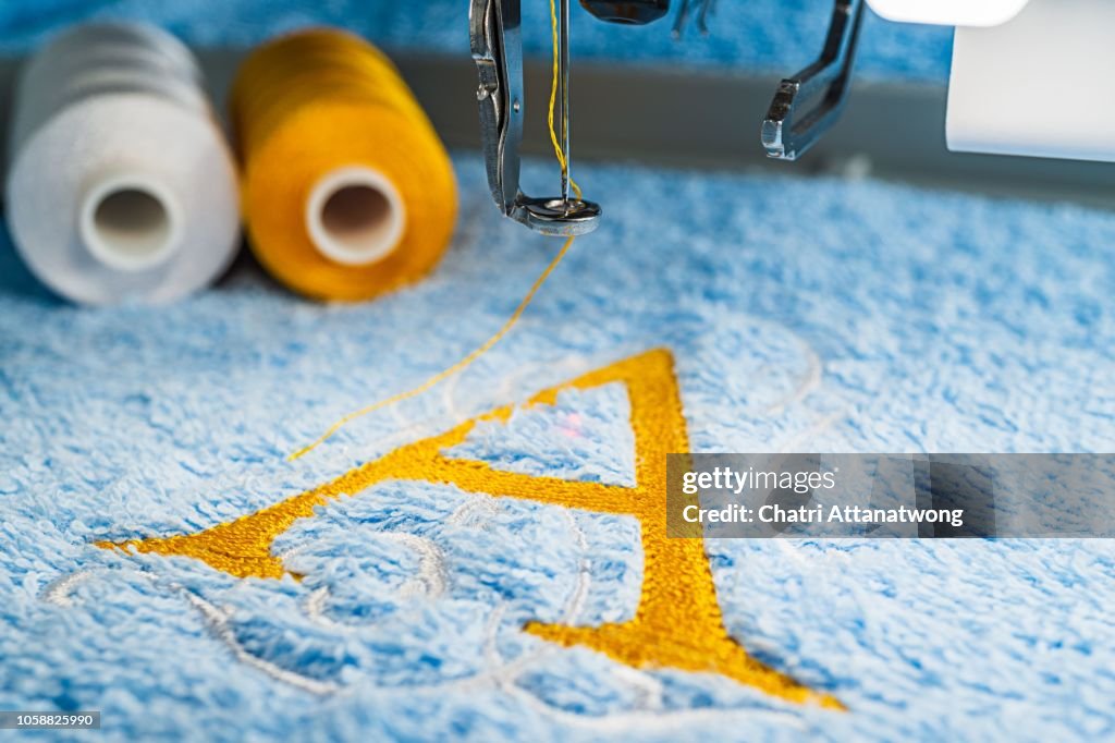 A alphabet design on towel in hoop of embroidery machine