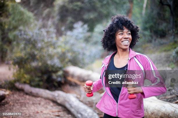 young black woman stretching with weights - the twist stock pictures, royalty-free photos & images