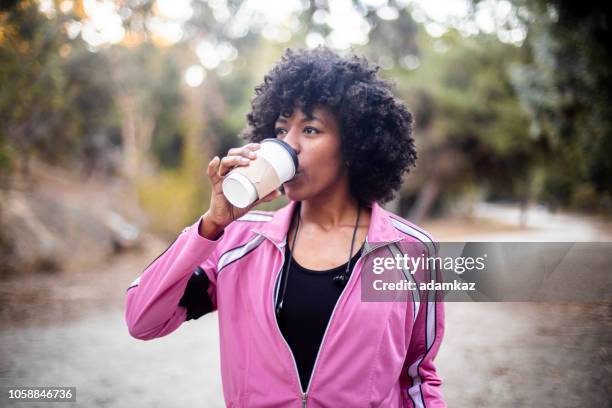 junge schwarze frau zu fuß mit kaffee - hot pink stock-fotos und bilder