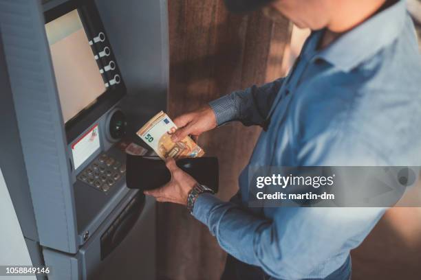 empresario en el cajero automático de retiro de dinero, billetes falsos de cincuenta euros - euros fotografías e imágenes de stock