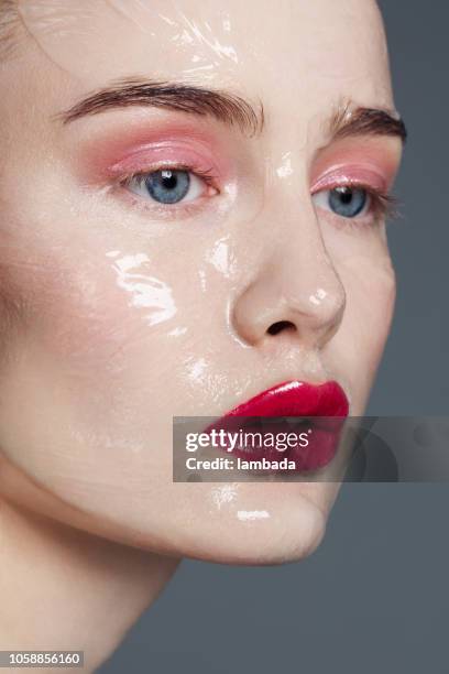 beautiful woman with skin care product on her face - gel effect lighting stock pictures, royalty-free photos & images