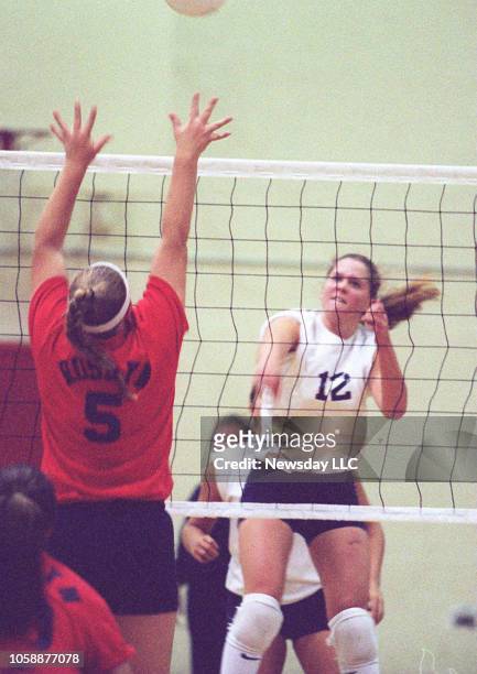Team captain Amy Schumer of South Side High School, spikes the volleyballl to Roslyn High School's Theresa Ceriello in a girls varsity volleyball...