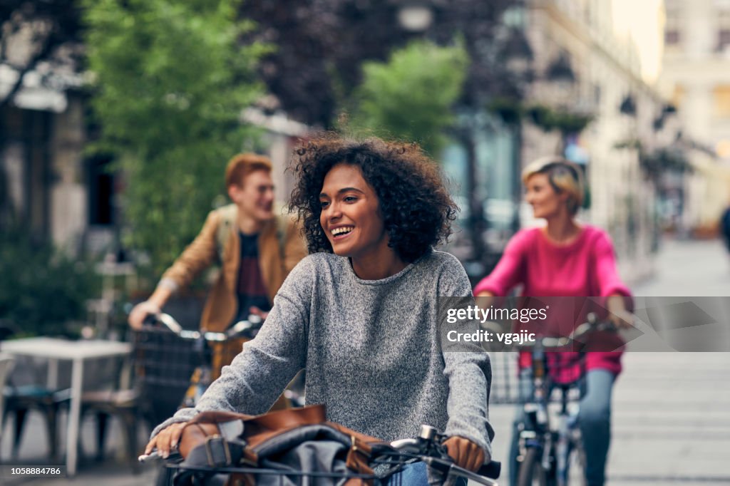 Amigos, andar en bicicleta en una ciudad