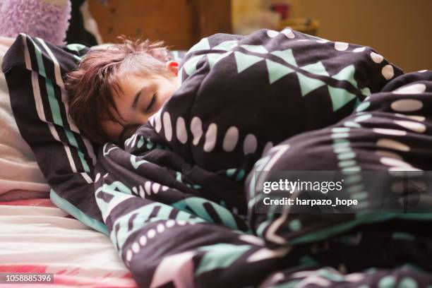 teenager asleep and wrapped in a blanket. - teen sleeping bedroom stock pictures, royalty-free photos & images