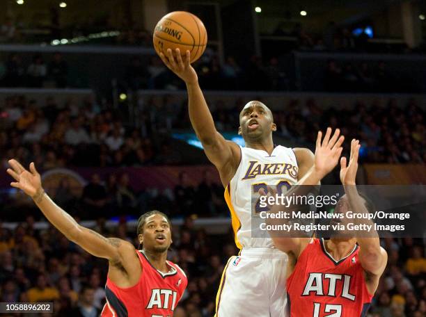 The Los Angeles Lakers' Jodie Meeks goes over the Atlanta Hawks' Cartier Martin, left, and John Jenkins at Staples Center in Los Angeles, CA on...