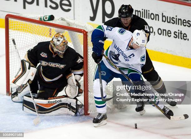 Vancouver's Henrik Sedin sets up a shot in front of the Ducks' Cam Fowler and goalie Frederik Anderson at Honda Center in Anaheim on November 10,...