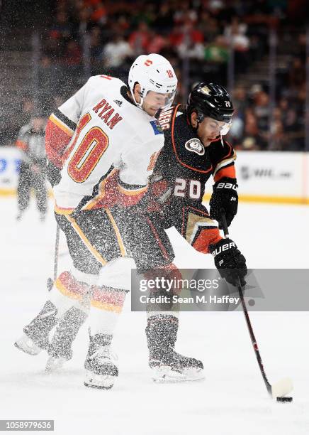 Derek Ryan of the Calgary Flames and Pontus Aberg of the Anaheim Ducks battle for a loose puck during the first period of a game at Honda Center on...