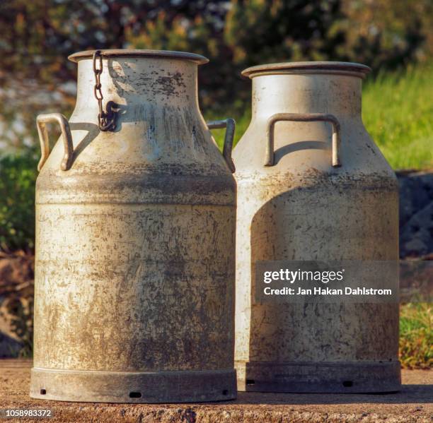 old milk churns - melkpak stockfoto's en -beelden