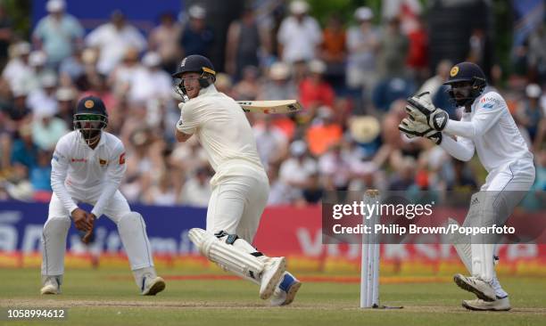 Ben Stokes of England hits out watched by Niroshan Dickwella of Sri Lanka during the third day of the 1st Cricket Test Match between Sri Lanka and...