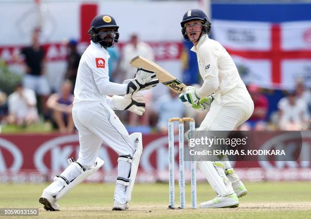 England's cricketer Keaton Jennings plays a shot as Sri Lanka's wicketkeeper Niroshan Dickwella looks on during the third day of the opening Test...