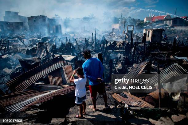 Residents look at destroyed houses after a fire engulfed a slum area in Navotas along Manila Bay on November 8, 2018. - Some 150 families were...