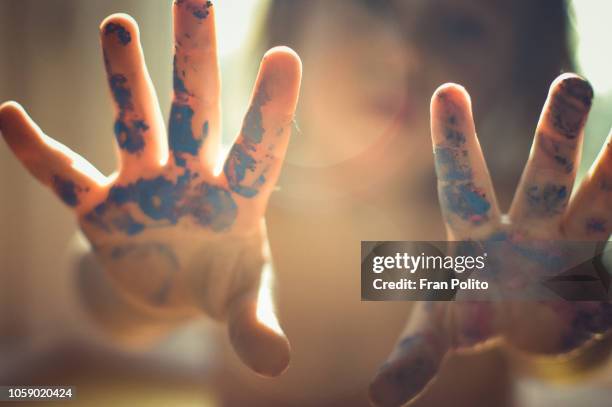 toddlers hands covered in paint. - finger painting stock-fotos und bilder