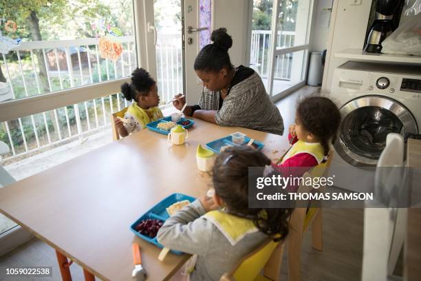 Children sit in the kitchen as they eat their lunch at the welcome center's apartment part of the French humanitarian association Red Cross the...