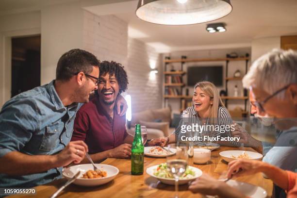 friends and family dining together and having fun - large family stock pictures, royalty-free photos & images