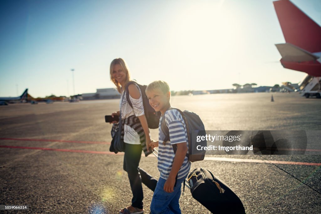 Mother and son walking on airstrip