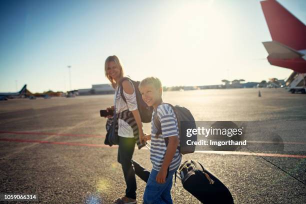 mother and son walking on airstrip - air strip stock pictures, royalty-free photos & images