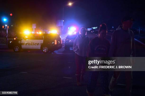 People walk away from the scene as it unfurls at the intersection of US 101 freeway and the Moorpark Rad exit as police vehicles close off the area...