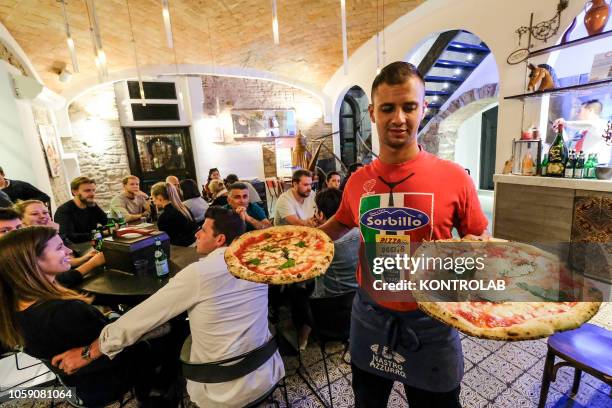 Waiter serve two pizza Margherita prepared by pizza maker Gino Sorbillo at Sorbillo Pizzeria in Naples. Sorbillo pizzeria is one of most important...