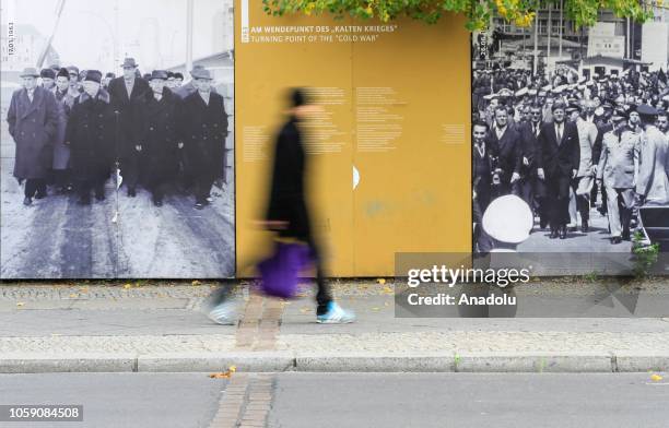 People walk past posters on the 29th anniversary of the fall of the Berlin Wall in Berlin, Germany on November 8, 2018. Brandenburg Gate is an...