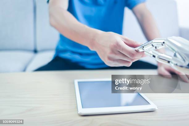 umano che stringe la mano al robot all'interno - cyborg foto e immagini stock