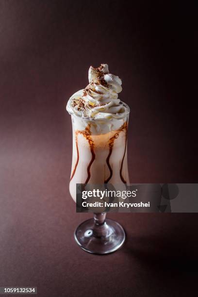 frappucino with whipped cream on elegant dark brown background - coffee frappe stock-fotos und bilder