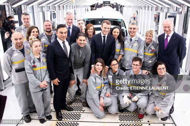 French President Emmanuel Macron and Renault CEO Carlos Ghosn pose with employees of the Renault factory after a visit in Maubeuge, northeastern...