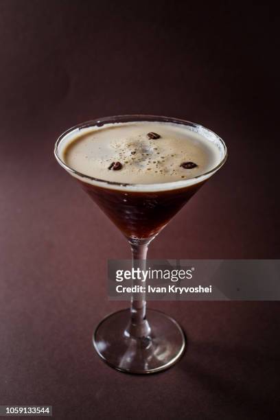 glass of espresso martini with coffee beans and vodka on elegant dark brown background - espresso drink stock pictures, royalty-free photos & images