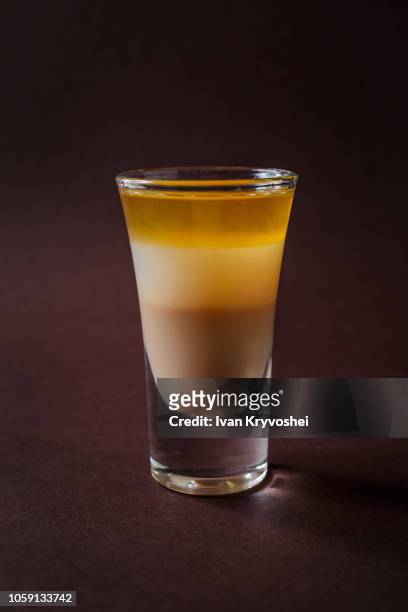 bmw alcoholic shot glass with irish cream, whiskey, coconut liquor on elegant dark brown background - bmw 3 stock pictures, royalty-free photos & images