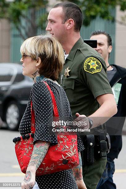 Janine Lindemulder is escorted into the Lamoreaux Justice Center by Orange County Sheriff Deputies after a confronting photographer on October 21,...